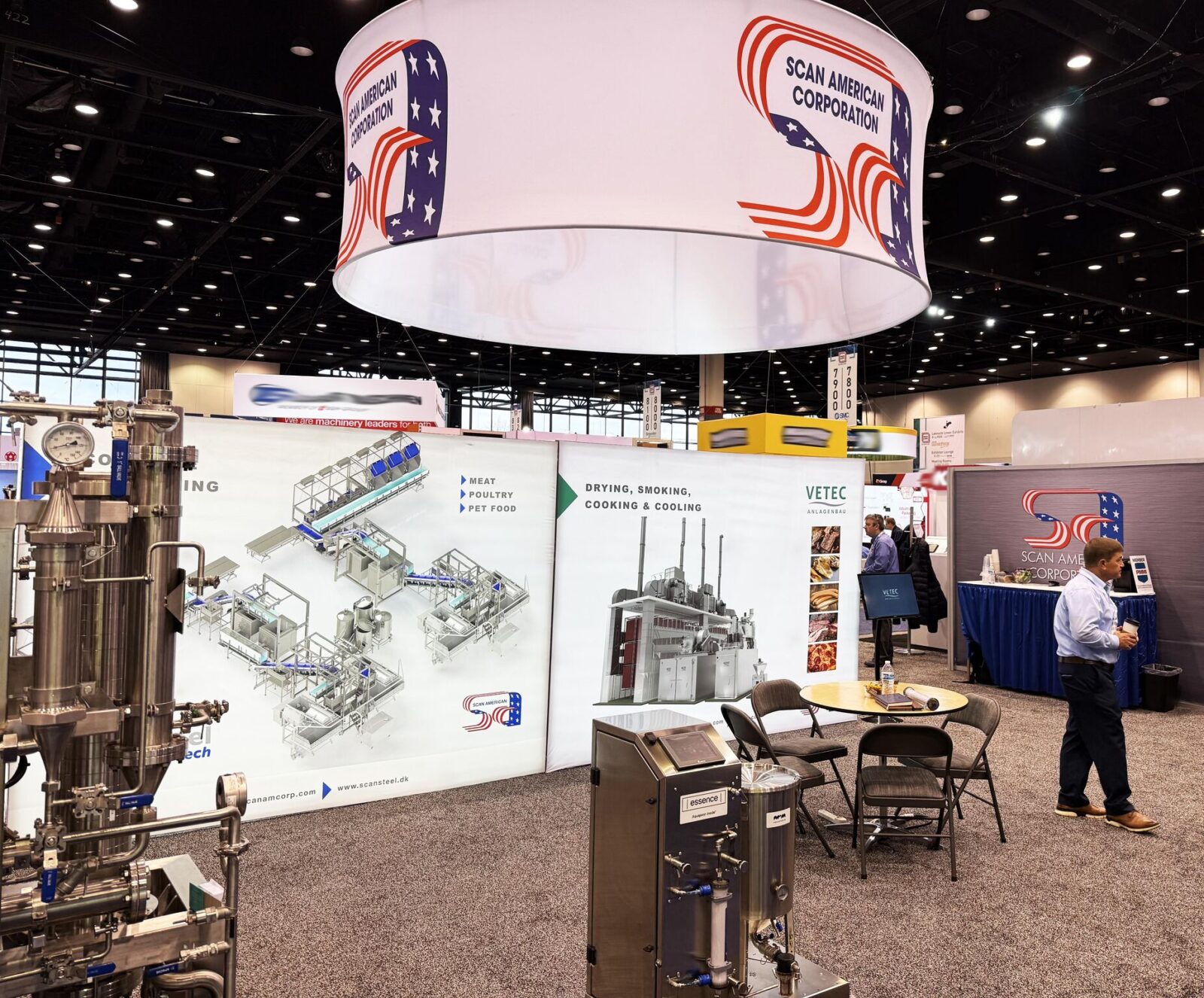 Vetec and Scansteel displays on the right side of the Scan American booth at Pack Expo 2024, with a few Scan American employees visible.