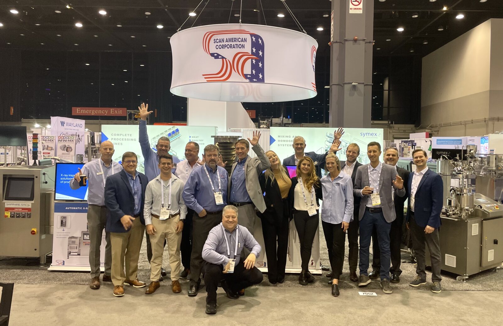 Group photo of the Scan American team and partners standing in front of the booth at Pack Expo 2022.